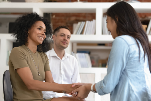 A social worker holds a client’s hands.