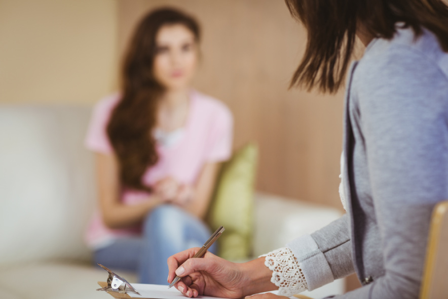 A social worker talking to a client with a clipboard.